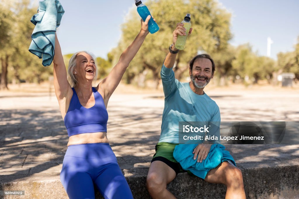 Two men celebrating their victories with raised hands, symbolizing achievement and success in fitness. Fitness Motivation Tips.