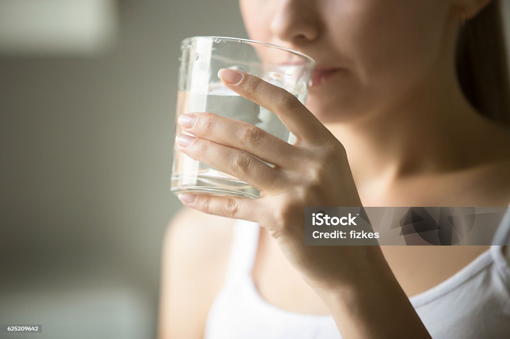 Woman drinking a glass of water, highlighting hydration benefits. Simple Diet Changes for Weight Loss: Drink More Water for effective results.