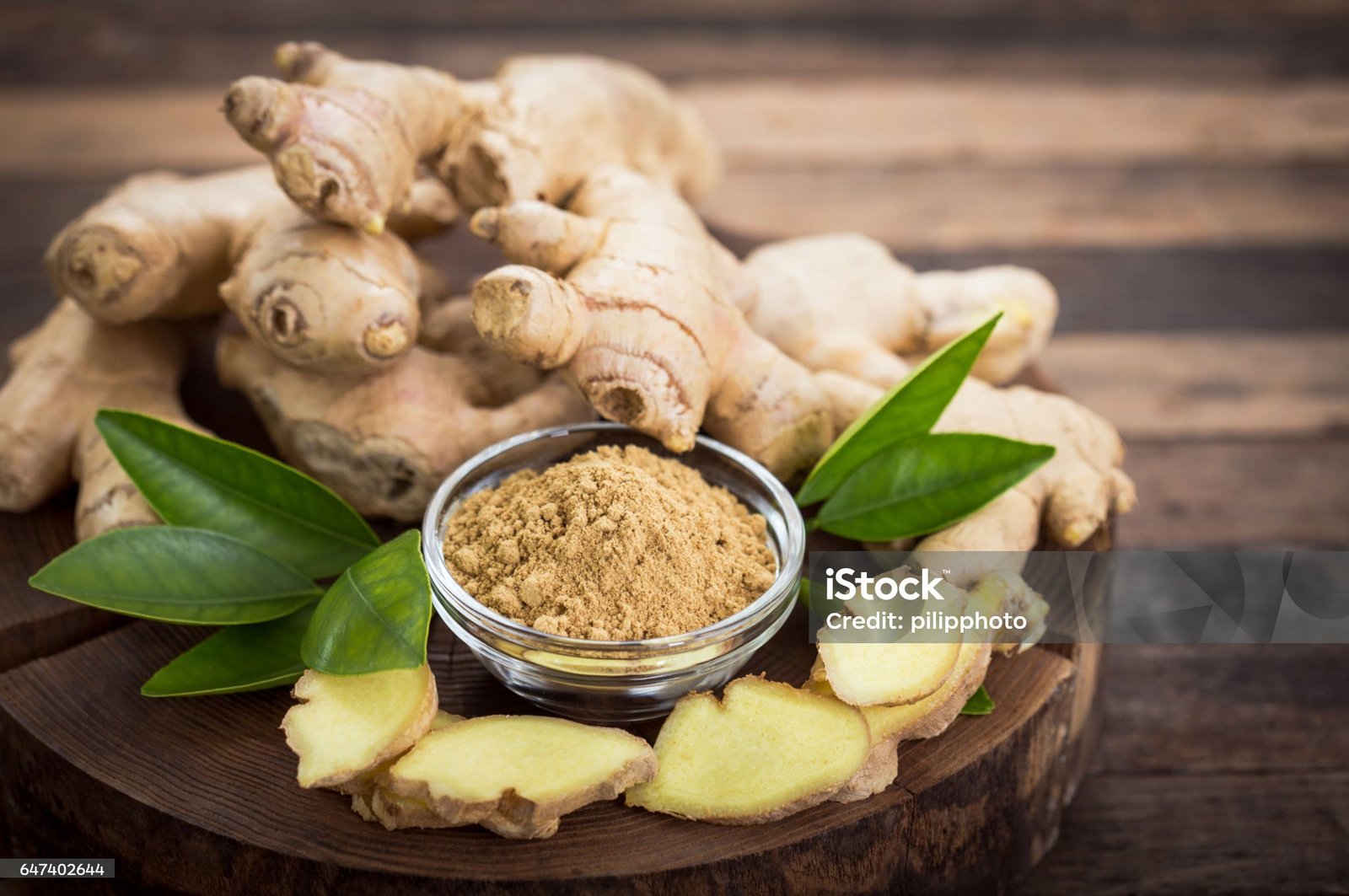 Fresh ginger root, known for its medicinal properties and health benefits of ginger, displayed on a wooden cutting board.