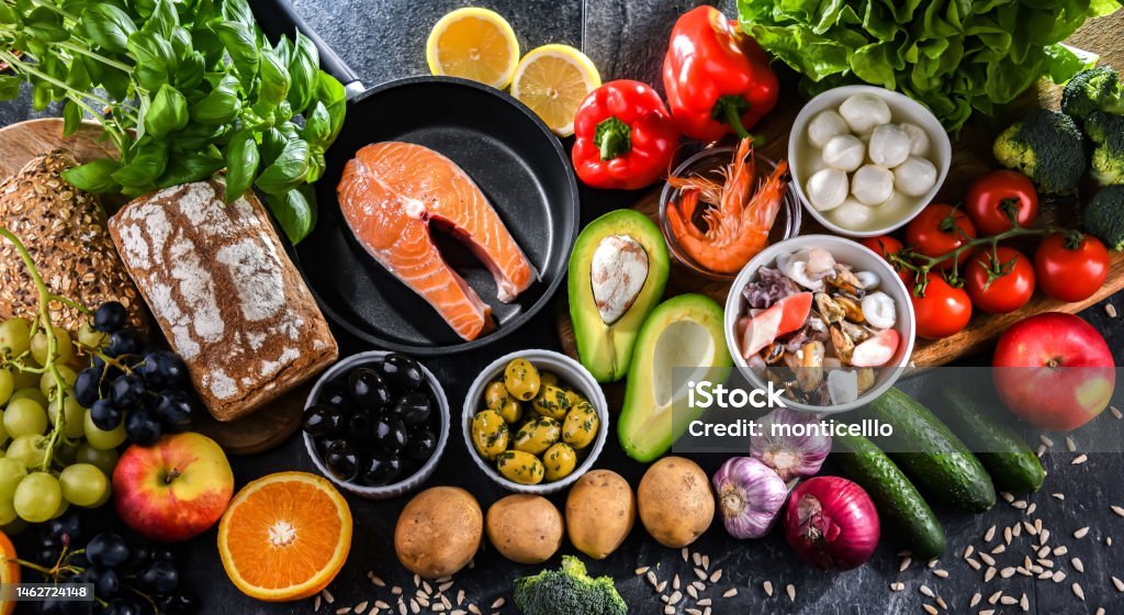 Assortment of food products representing the Mediterranean diet, showcasing fruits, vegetables, whole grains, nuts, and olive oil, which may improve overall health status .