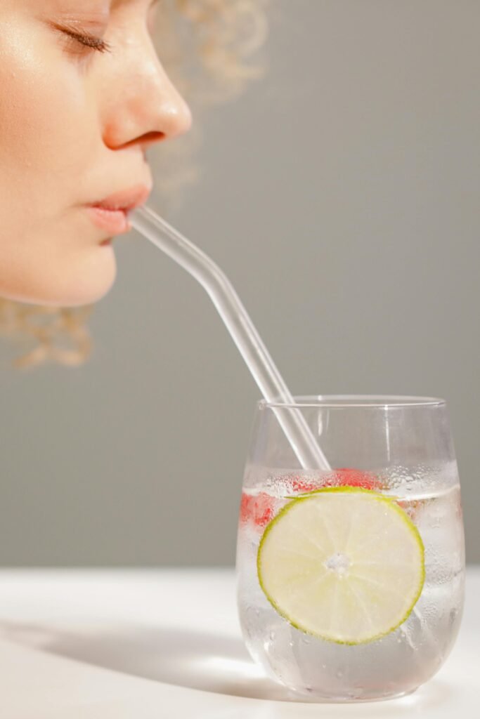 Glass of water with lemon slices emphasizing hydration.