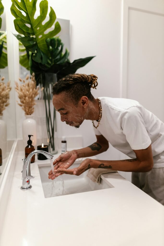 Man cleansing his face with a gentle facial cleanser as part of his men’s skincare routine.