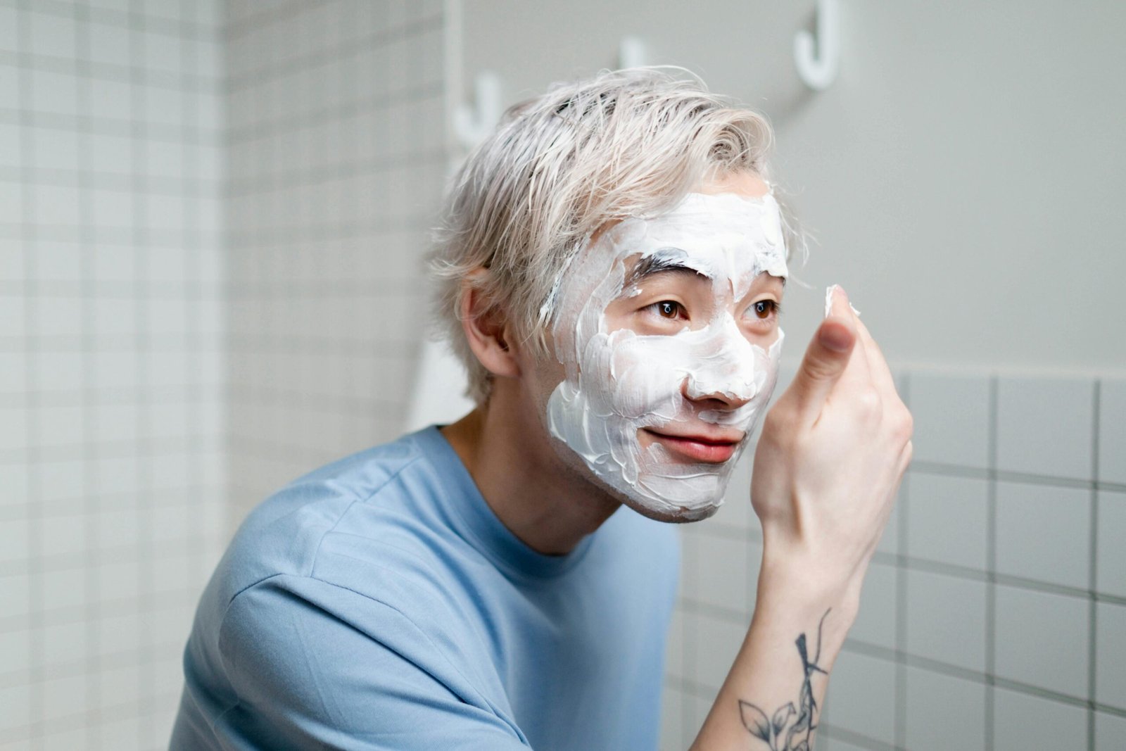 Man following his skincare routine, applying products for a healthy and refreshed complexion.