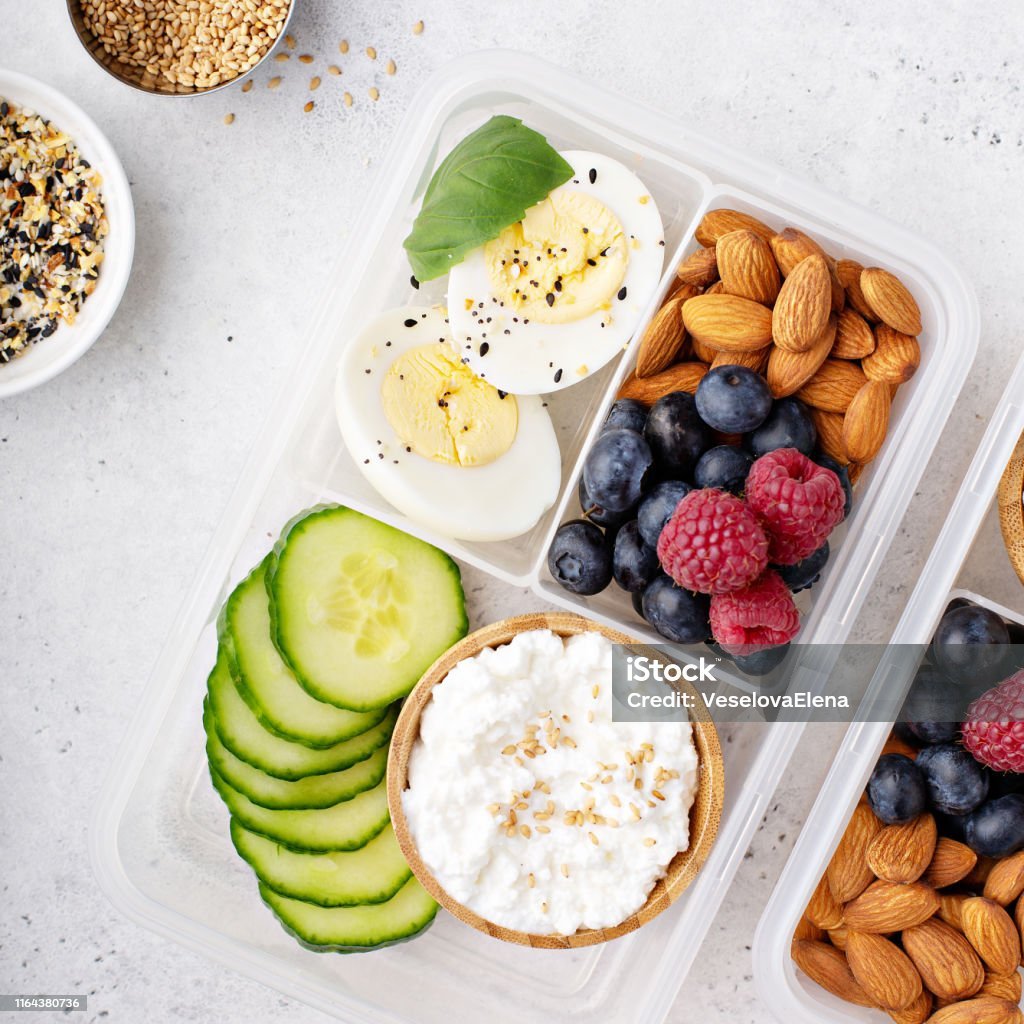 High-protein lunch or snack box featuring cottage cheese, nuts, and eggs for a healthy diet and weight loss.