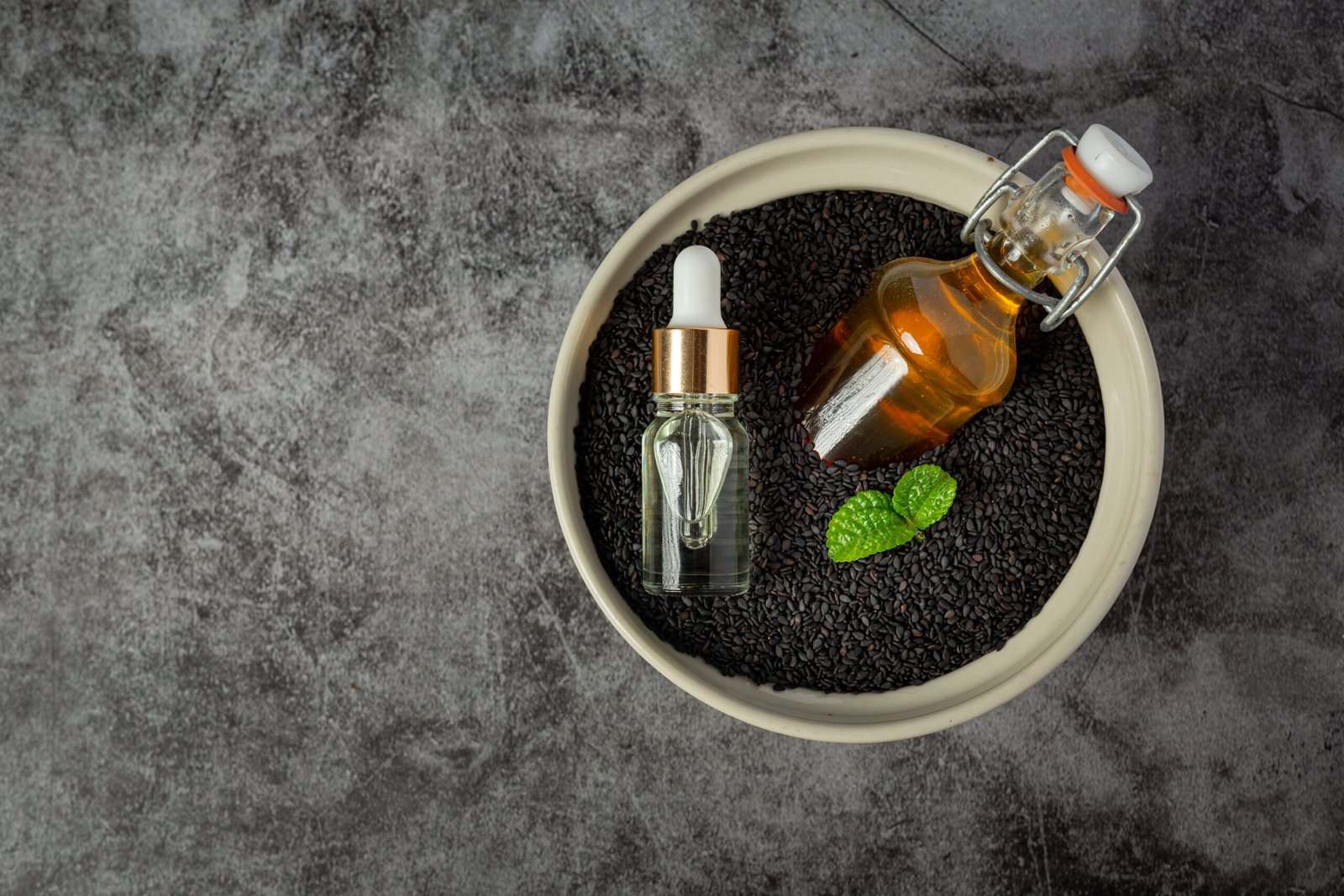 Bottle of black pepper essential oil with black pepper seeds in the background, highlighting its therapeutic uses.